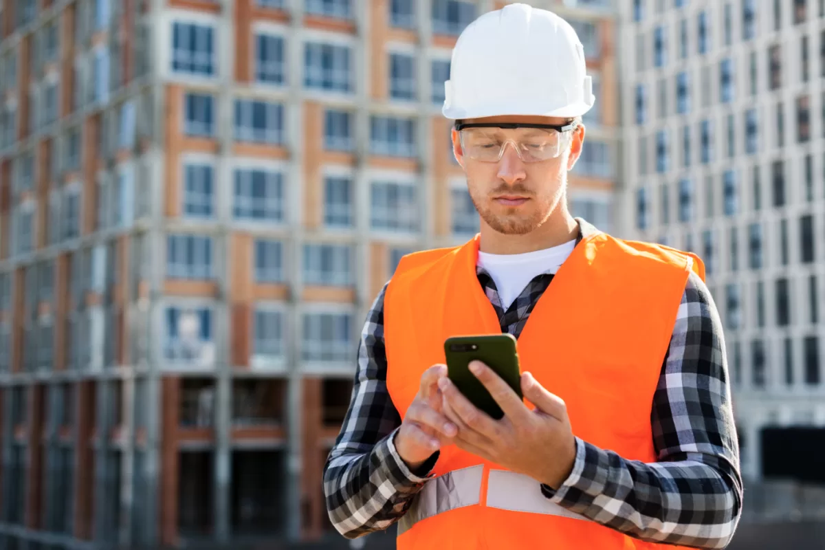 Operaio che gestisce il cantiere da smartphone